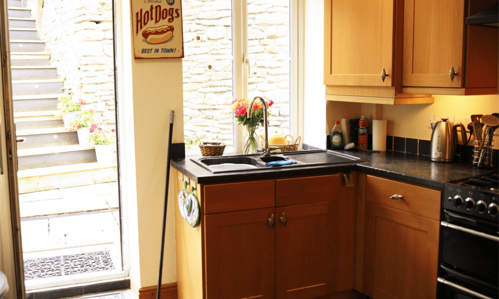 Back door of Hay-on-Wye holiday cottage opening onto a private, sunny patio garden with outdoor seating