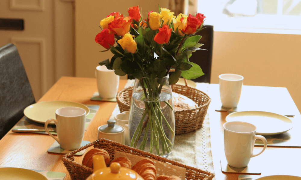Close-up of rustic wooden dining table set for guests at Hay-on-Wye holiday cottage