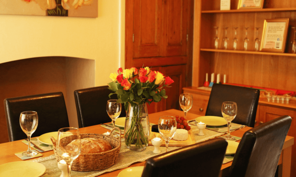 Dining table at Hay-on-Wye holiday cottage with family board games on shelves in the background – perfect for indoor fun